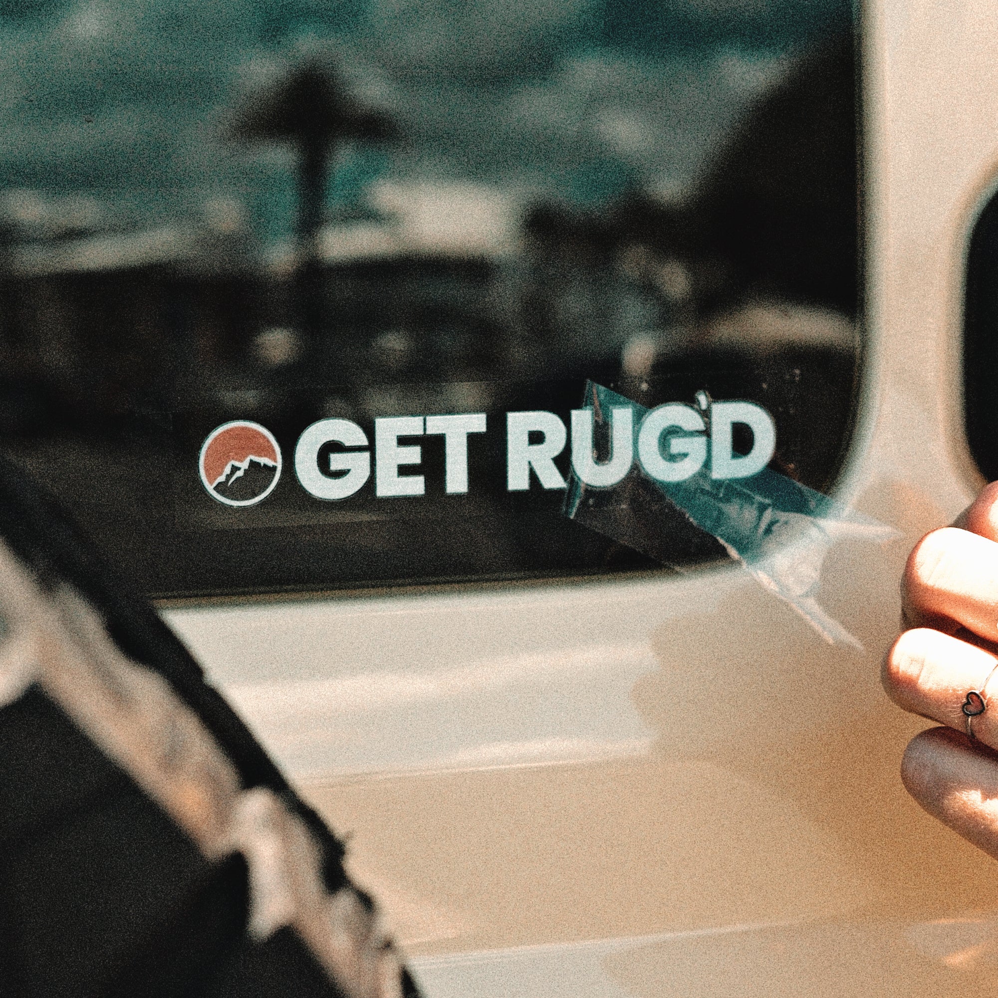 Get Rug'd car decal sticker coaster pack displayed on a car window