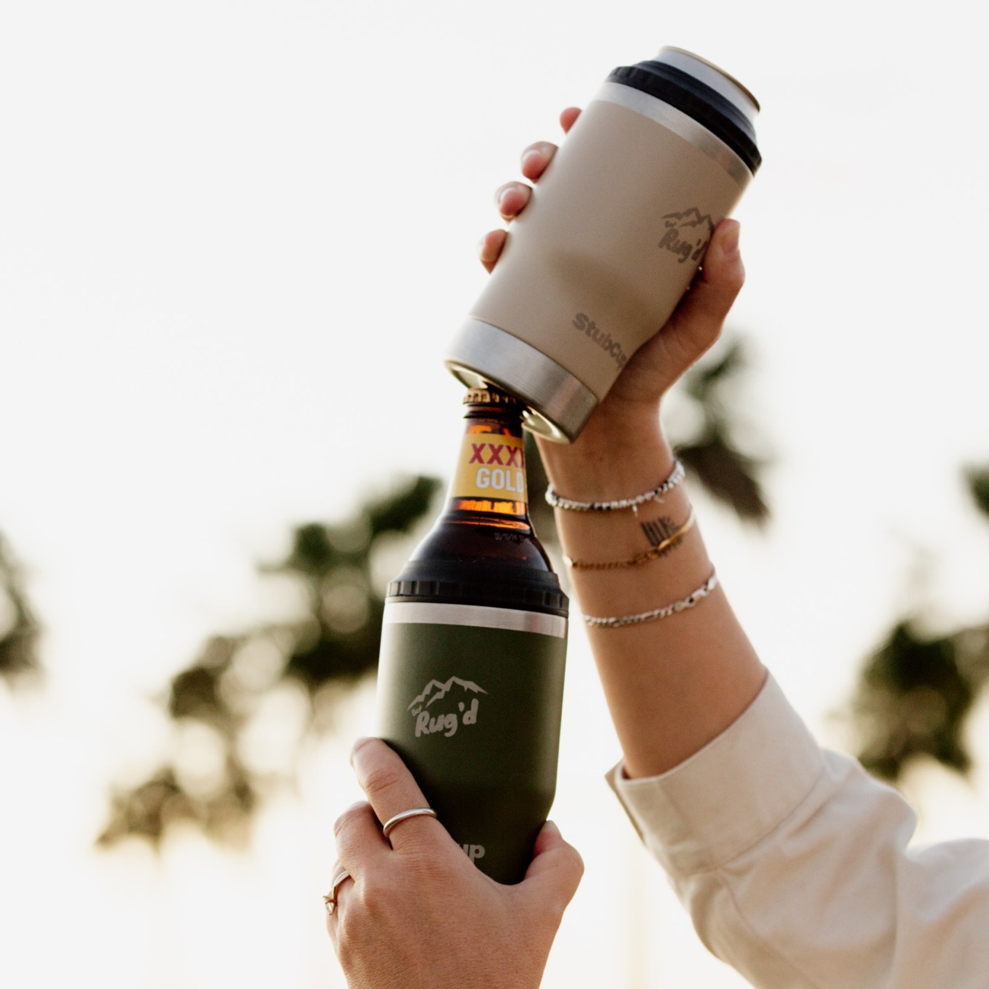 Person using StubCup Green Stubby Cooler Coffee Cup by Get Rugd to chill beer bottle outdoors