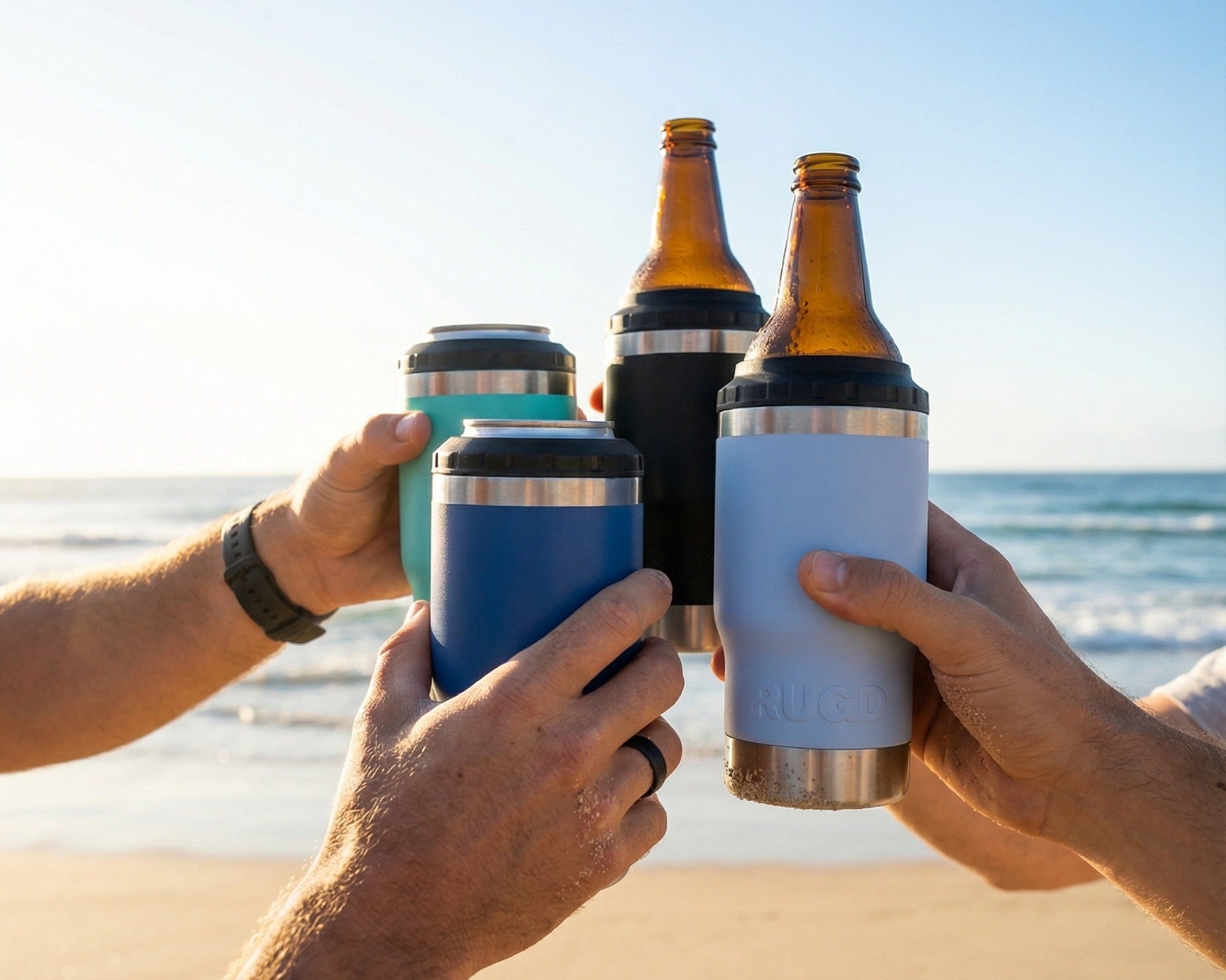 The Original Stubby Cooler and Coffee Cup from RUGD. 4 Perople Cheersing on the beach. Australian designed.