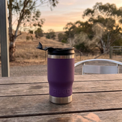 Get Rug'd StubCup Purple tumbler purple beer drinking cup on a wooden table outdoors