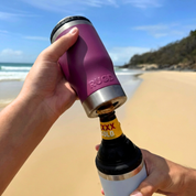 Get Rug'd StubCup Grape stubby cooler coffee cup used on a beach while opening a bottle