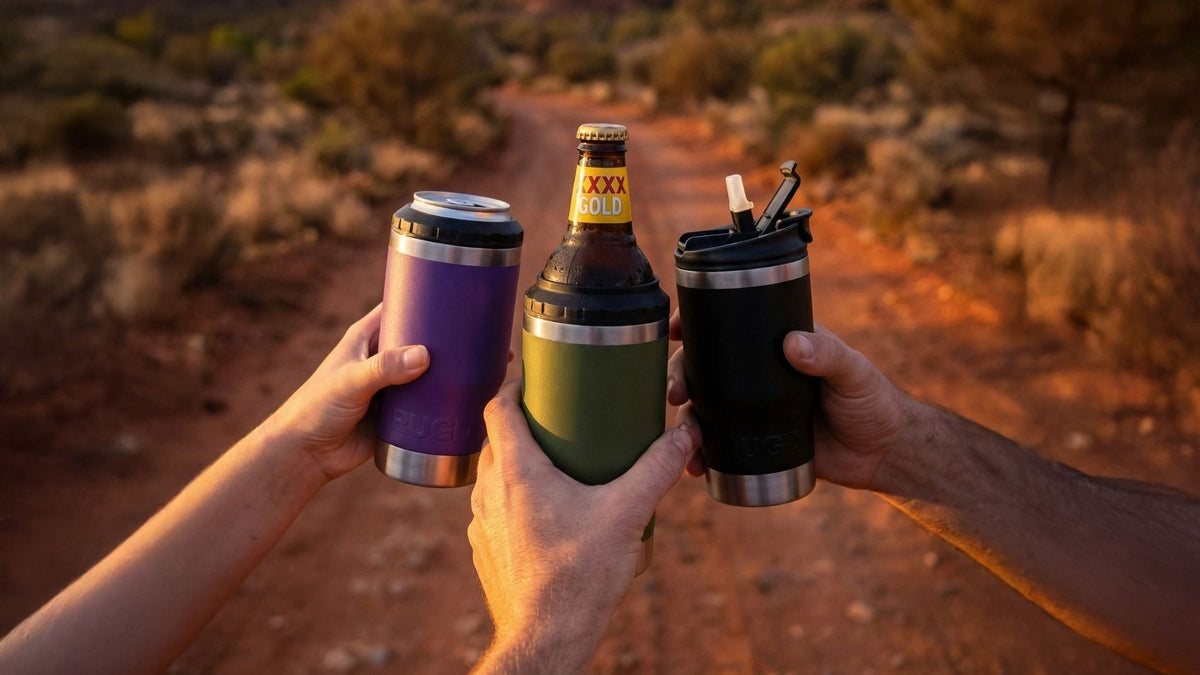 Three StubCups raised together on an outback track at sunset