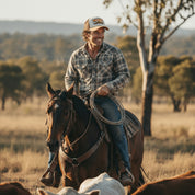Get Rug'd Cap worn by a cowboy riding a horse in a rural setting with a plaid shirt