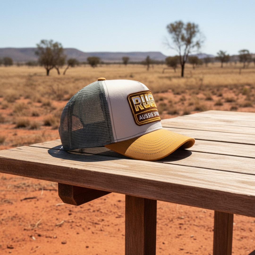 Get Rug'd Aussie Spirit Cap with Mesh Backing in Gray and Yellow on a Wooden Table Outdoors