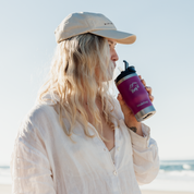 Get Rug'd StubCup Grape stubby cooler coffee cup held by a woman on the beach
