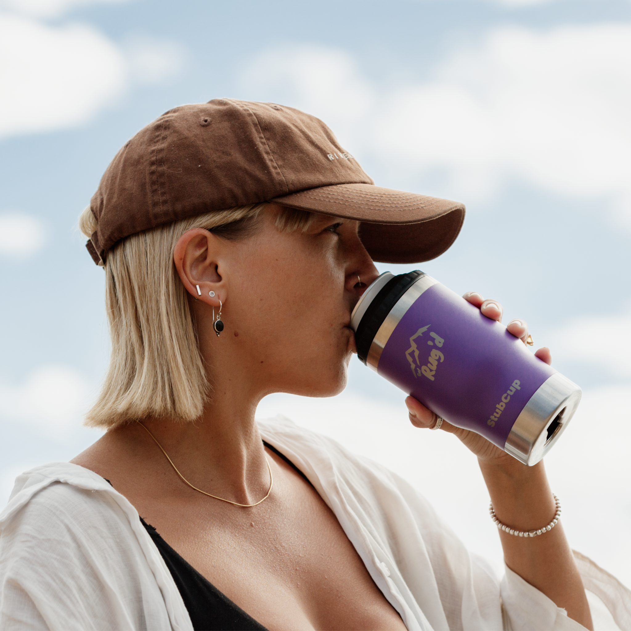 Woman sipping from a StubCup stainless steel tumbler purple beer drinking cup outdoors