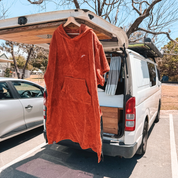 Get Rug'd Towel Poncho in Orange Hanging on a Van for Beach and Pool Use